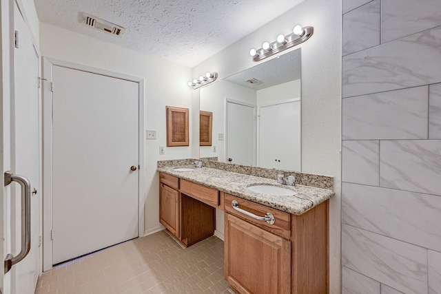 bathroom featuring vanity, a textured ceiling, and tile patterned floors