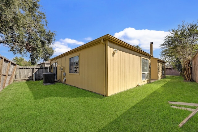 view of home's exterior with cooling unit and a lawn