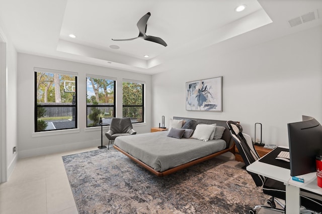 tiled bedroom with a raised ceiling and ceiling fan