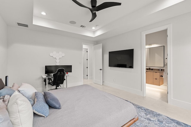 bedroom featuring ensuite bathroom, a raised ceiling, and ceiling fan