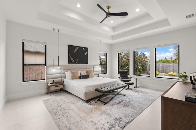 bedroom with a raised ceiling, ceiling fan, and light tile patterned floors