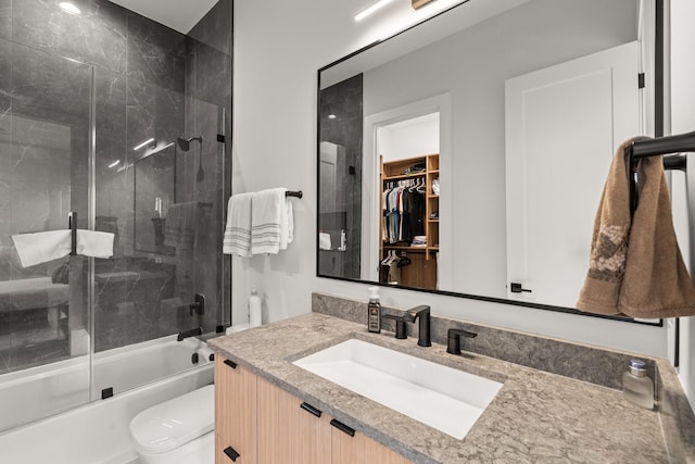 full bathroom featuring vanity, bath / shower combo with glass door, and toilet