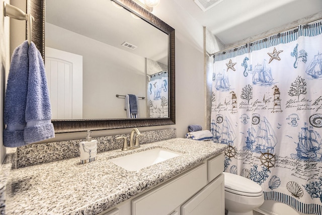bathroom featuring vanity, curtained shower, and toilet