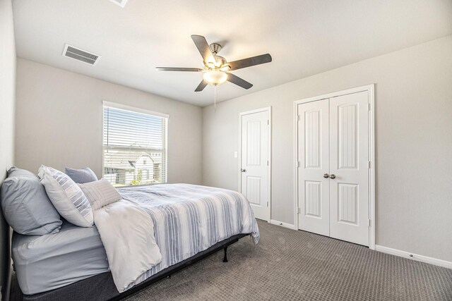 carpeted bedroom featuring multiple closets and ceiling fan