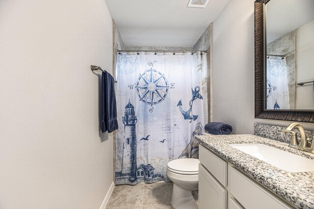 bathroom featuring tile patterned flooring, a shower with curtain, vanity, and toilet