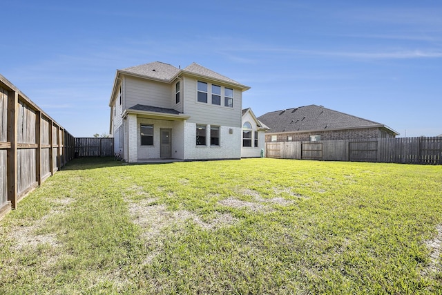 back of house with a lawn