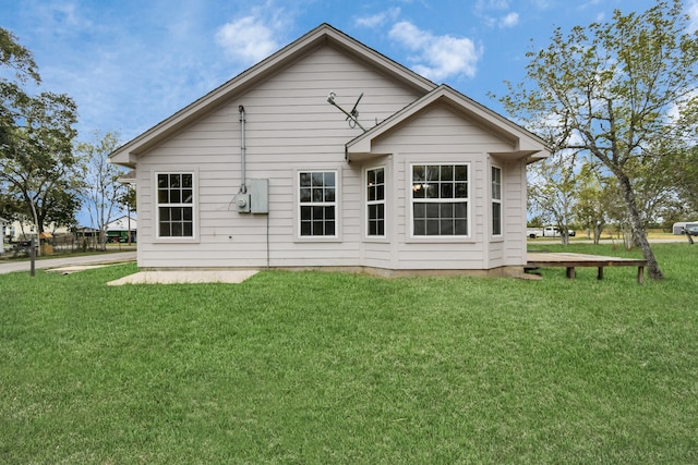 rear view of house featuring a yard