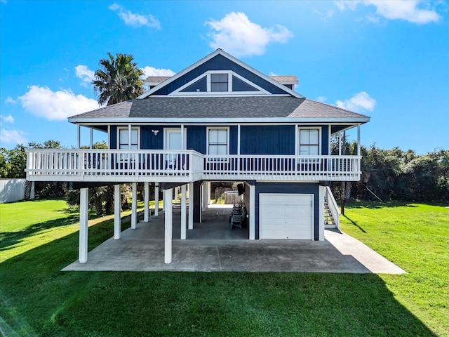 back of property with stairway, roof with shingles, a porch, a garage, and a lawn