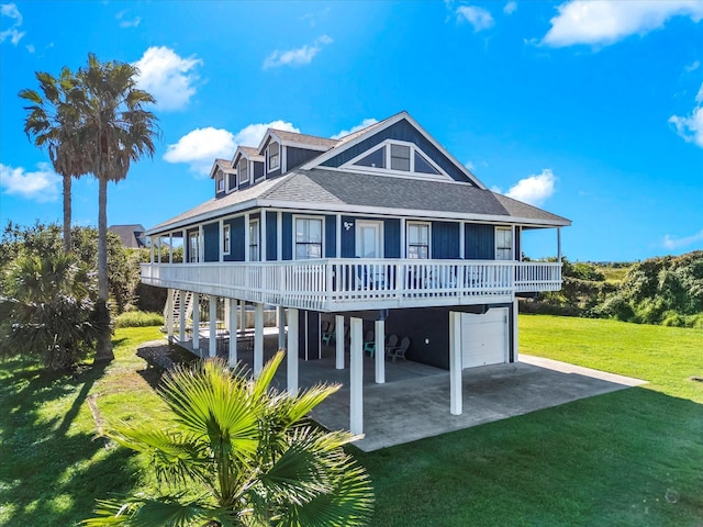 back of property with a lawn, a patio area, and a garage