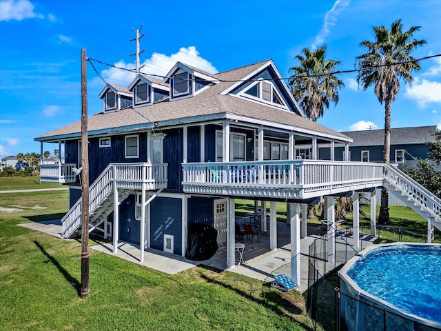 back of property featuring a swimming pool side deck, a yard, and a patio