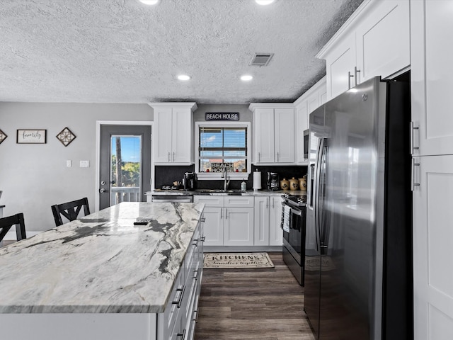 kitchen featuring a kitchen bar, white cabinets, and stainless steel appliances