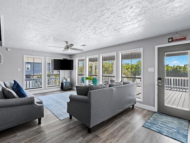 living room featuring a textured ceiling, hardwood / wood-style flooring, and ceiling fan