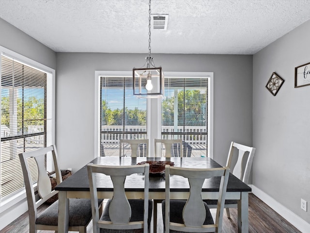 dining space featuring a textured ceiling and dark wood-type flooring