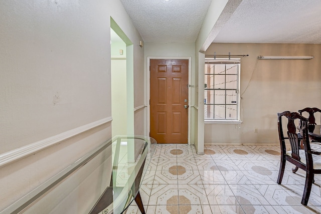 tiled foyer featuring a textured ceiling