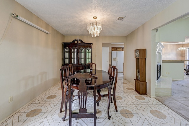 dining space featuring a textured ceiling and a chandelier