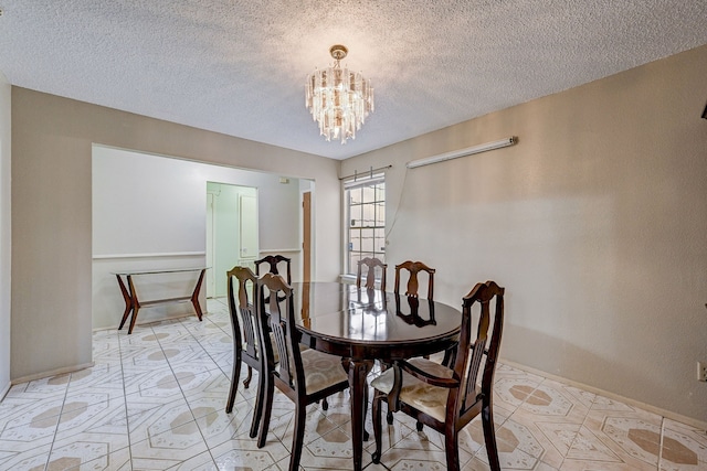 dining room featuring a textured ceiling and an inviting chandelier