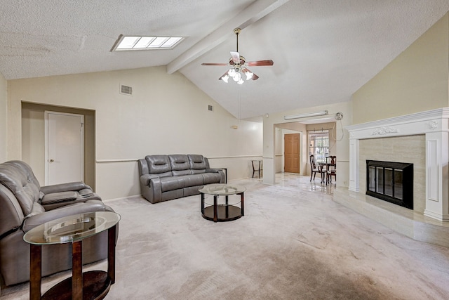 carpeted living room featuring a fireplace, a textured ceiling, lofted ceiling with beams, and ceiling fan