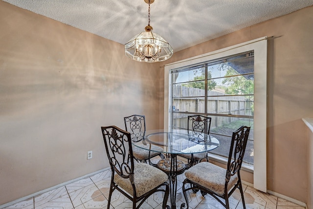 dining room with a textured ceiling and an inviting chandelier