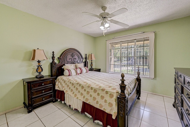 bedroom featuring ceiling fan, light tile patterned floors, and a textured ceiling