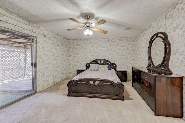 carpeted bedroom featuring access to exterior, ceiling fan, and a textured ceiling