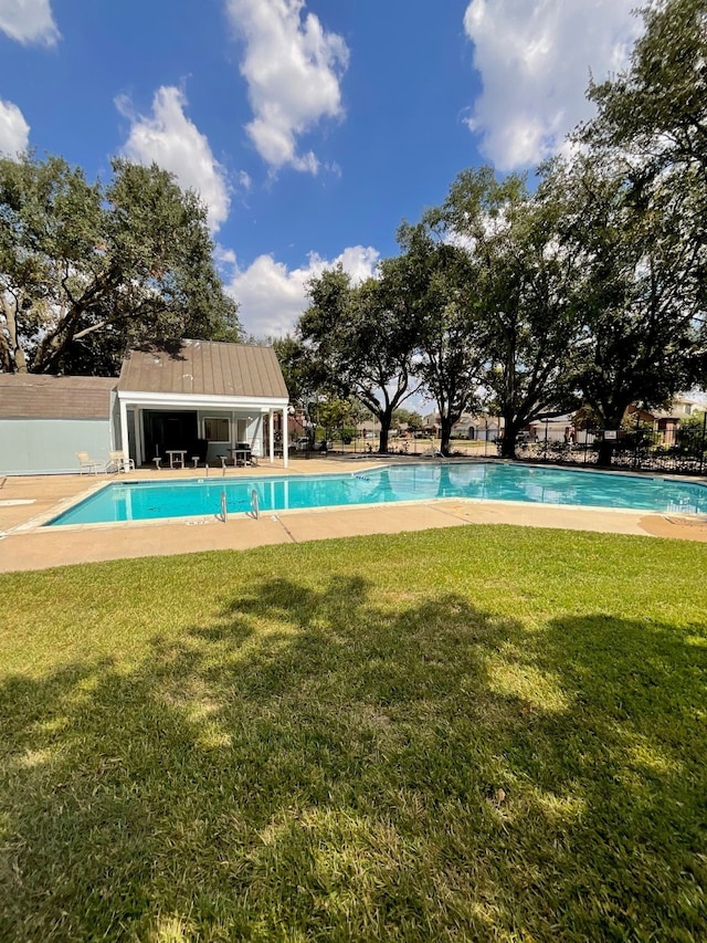 view of swimming pool featuring a lawn