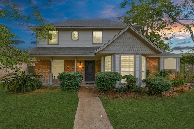 view of front of home with a lawn and a porch