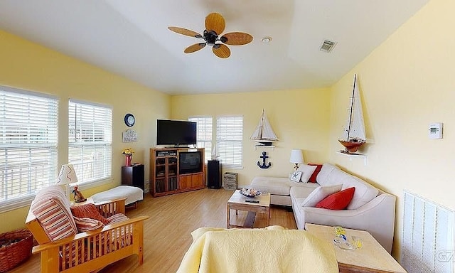 living room featuring wood-type flooring, ceiling fan, and a healthy amount of sunlight