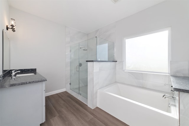 bathroom with plus walk in shower, wood-type flooring, and vanity