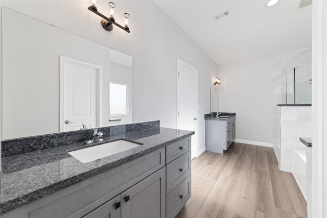 bathroom featuring a shower, vanity, and hardwood / wood-style flooring