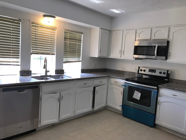 kitchen featuring white cabinets, a textured ceiling, stainless steel appliances, and sink