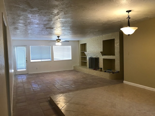 unfurnished living room with tile patterned flooring, a fireplace, ceiling fan, and a textured ceiling