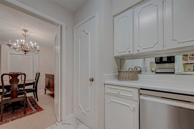 kitchen featuring white cabinetry, an inviting chandelier, a textured ceiling, decorative light fixtures, and stainless steel dishwasher