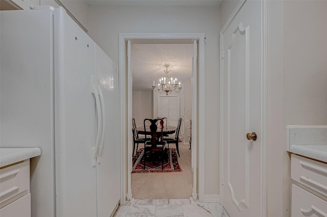 hall with a notable chandelier and a textured ceiling