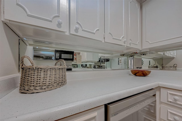 interior space featuring stainless steel dishwasher and white cabinets