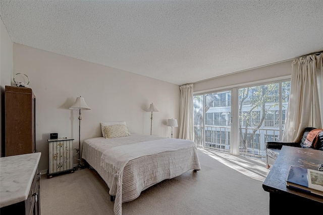 carpeted bedroom featuring access to exterior and a textured ceiling