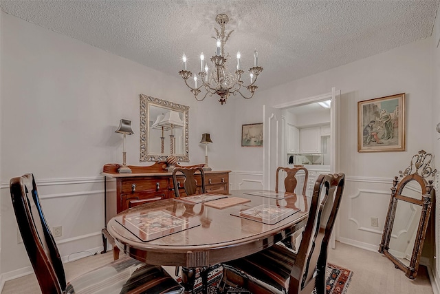 carpeted dining room featuring a chandelier and a textured ceiling