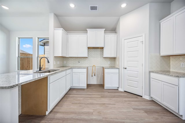 kitchen featuring white cabinetry, sink, and light hardwood / wood-style flooring