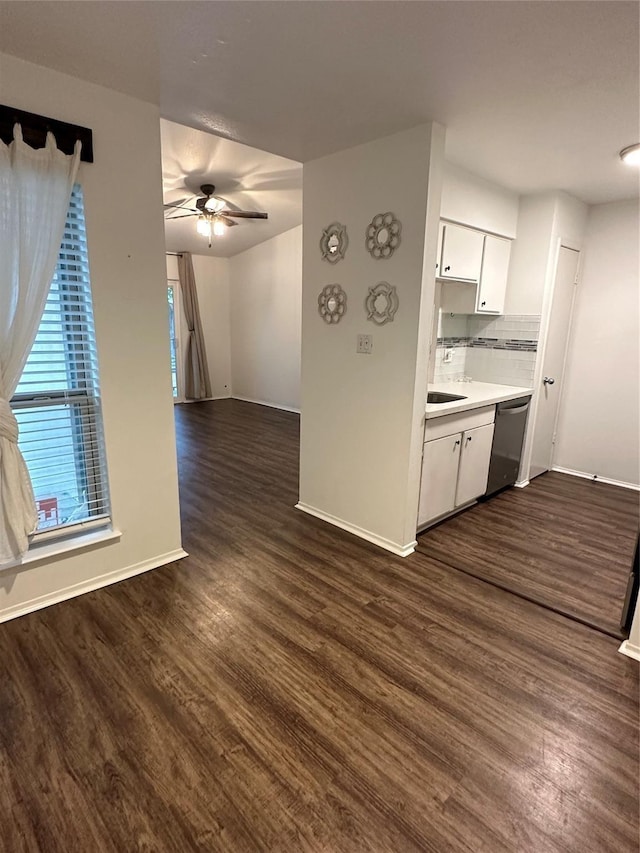 unfurnished living room featuring ceiling fan, sink, and dark wood-type flooring