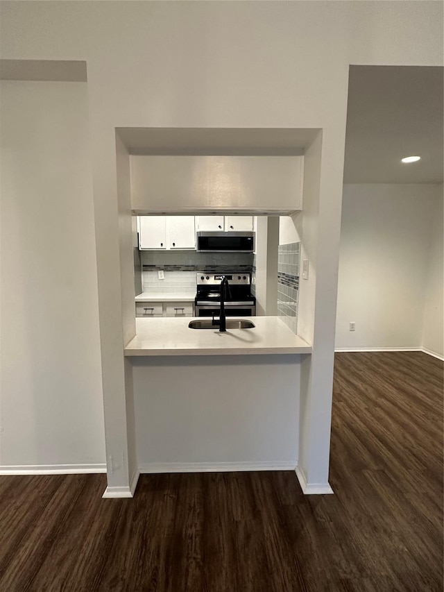 kitchen with dark hardwood / wood-style flooring, white cabinetry, sink, and stainless steel appliances