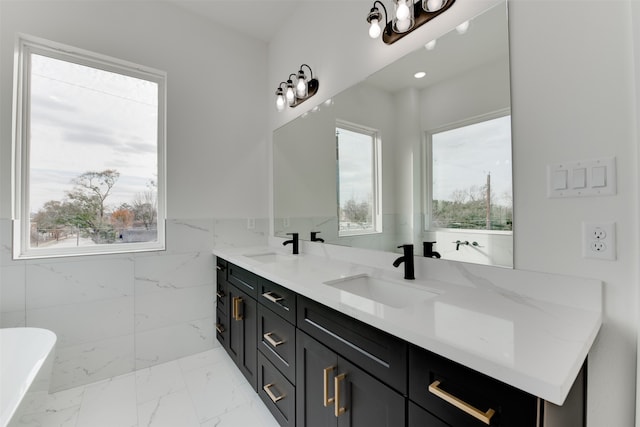 bathroom with a bathing tub, vanity, and tile walls