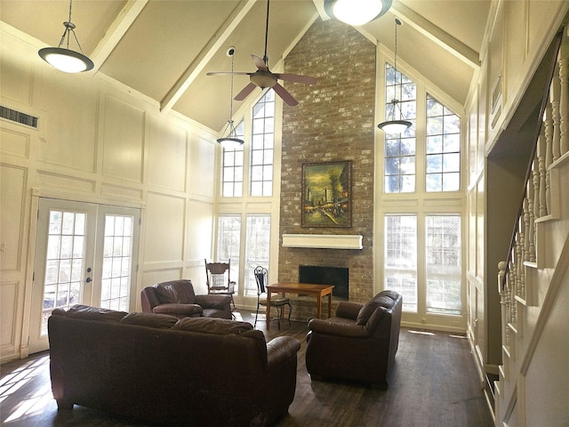 living room with beam ceiling, ceiling fan, french doors, high vaulted ceiling, and a fireplace