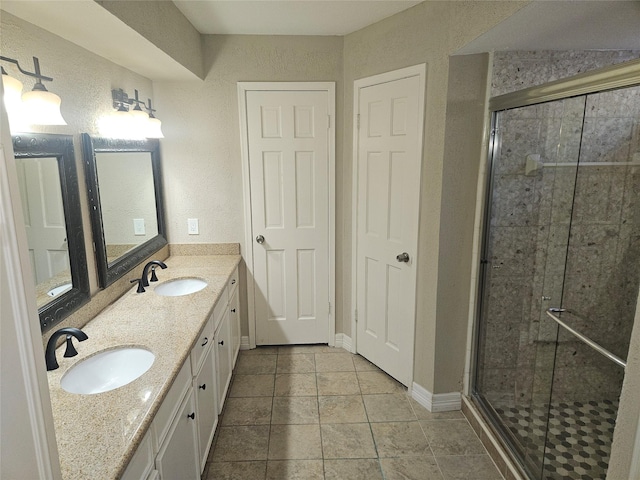 bathroom featuring a shower with door, vanity, and tile patterned flooring