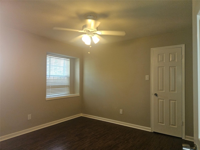 unfurnished room featuring ceiling fan and dark wood-type flooring