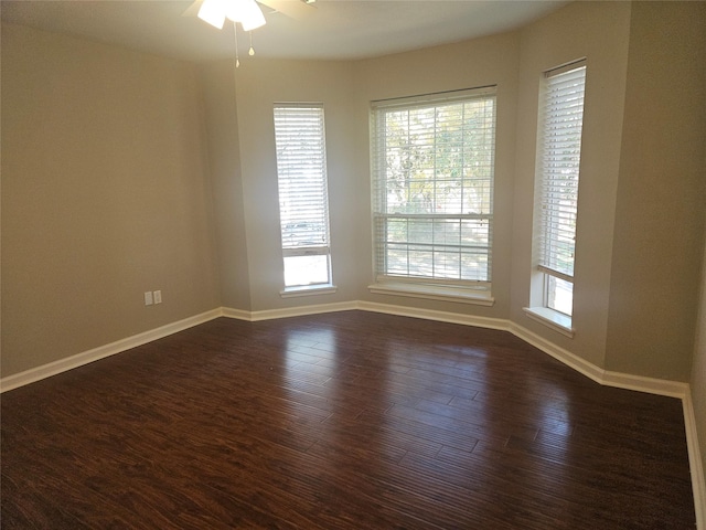 empty room with dark hardwood / wood-style flooring and ceiling fan