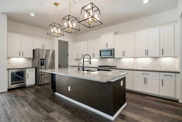 kitchen with decorative light fixtures, beverage cooler, dark wood-type flooring, and appliances with stainless steel finishes