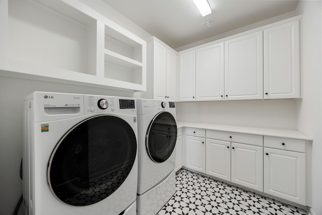 laundry room with washer and clothes dryer and cabinets