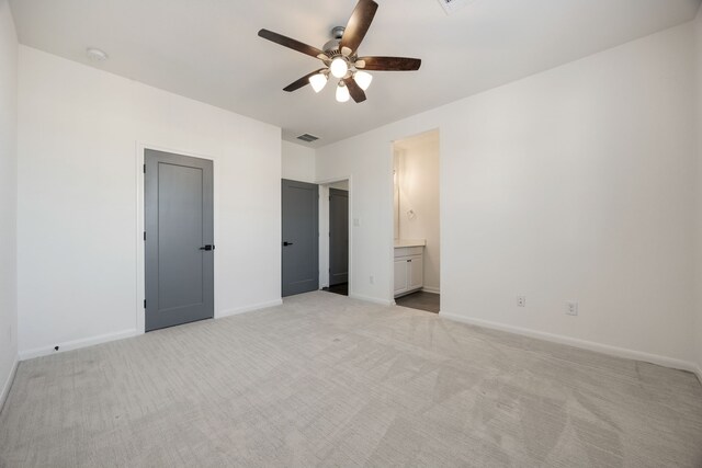 unfurnished bedroom with connected bathroom, ceiling fan, and light colored carpet