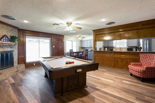 recreation room with hardwood / wood-style flooring, a fireplace, a textured ceiling, and billiards