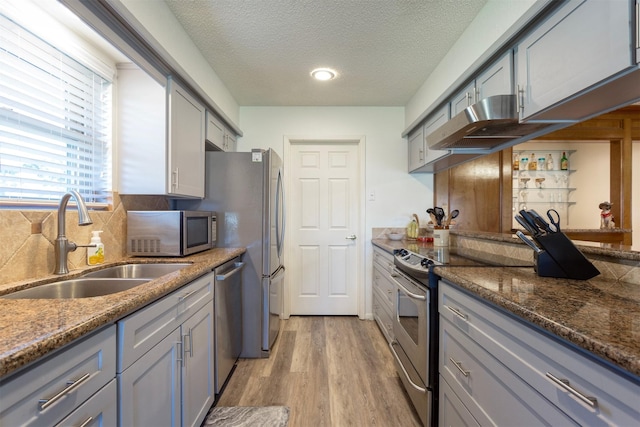 kitchen with stainless steel appliances, light hardwood / wood-style flooring, gray cabinetry, and sink