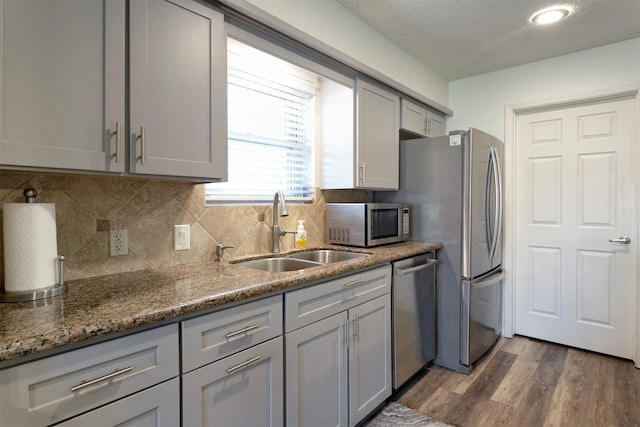 kitchen with gray cabinets, dark hardwood / wood-style flooring, sink, and stainless steel appliances